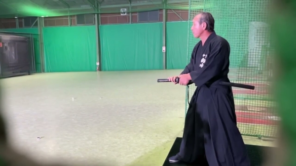 Mr. Miyagi slaat een honkbal op volle snelheid doormidden met zijn samurai-zwaard