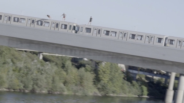 Adrenalinejunkies springen van een rijdende trein over een brug de rivier in