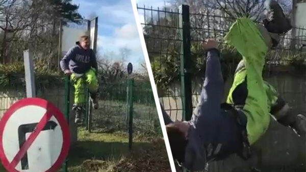 Collega heeft de nodige moeite om over een hek te klimmen