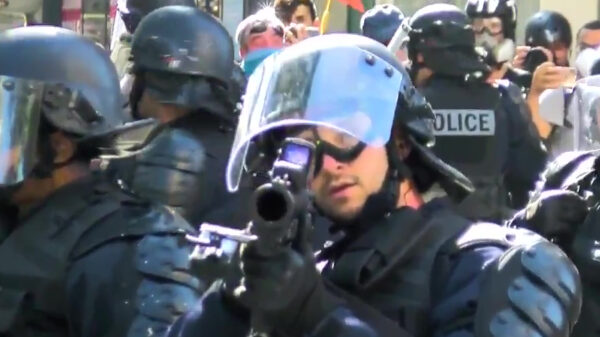 Een agent aan zijn wapen zitten is een garantie voor een gebroken neus