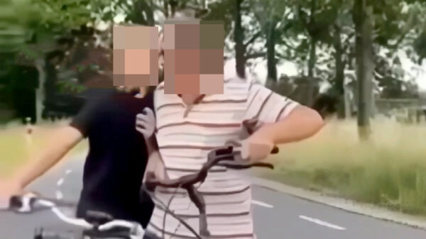 Oudere man op fiets staat neus aan neus met een aantal opgefokte pubers