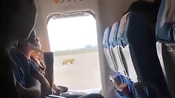 Chinese vrouw gooit nooddeur open in het vliegtuig voor wat frisse lucht!