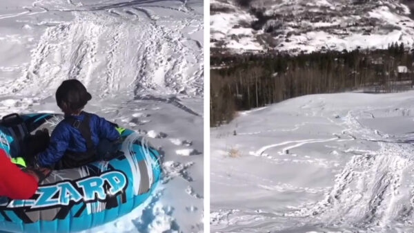 Vader van het jaar duwt zijn zoontje een besneeuwde heuvel af