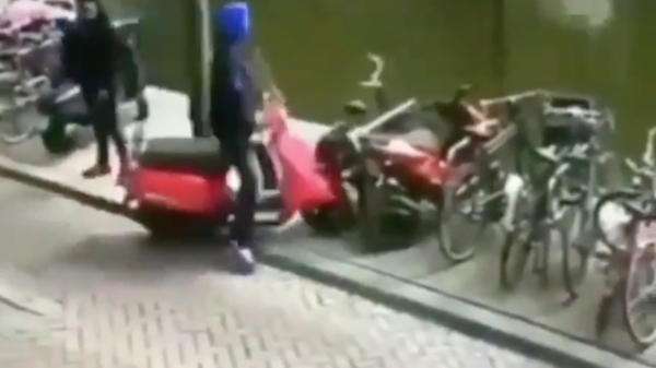 Sjap met capuchon heeft ietwat moeite om zijn scooter te parkeren