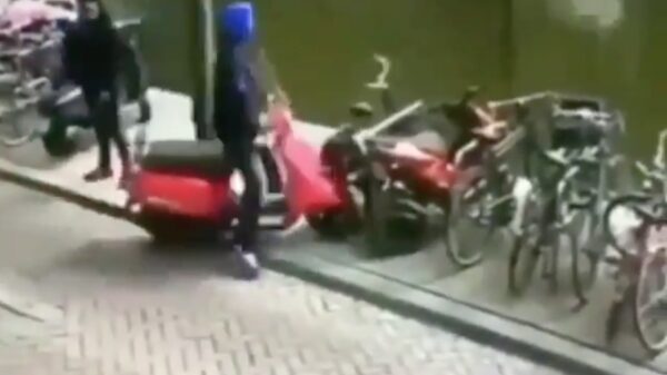 Sjap met capuchon heeft ietwat moeite om zijn scooter te parkeren