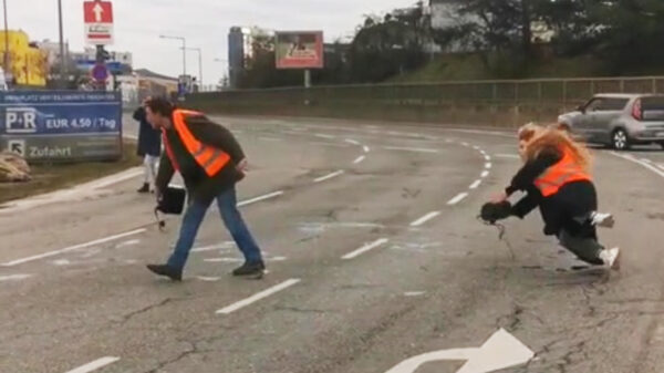 Klimaatgekkie onderuit terwijl ze olie op de weg gooit om de natuur te redden