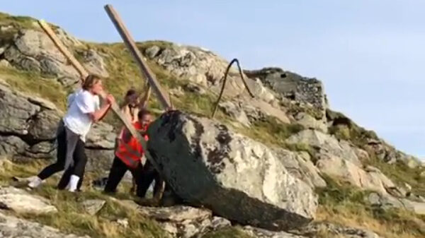 Mannen blijven mannen en joekelen een enorm rotsblok de zee in