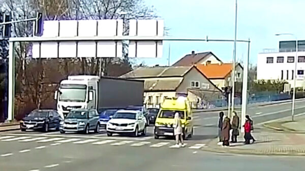 Voetgangers steken gewoon over terwijl er een ambulance met loeiende sirene's aan komt zetten