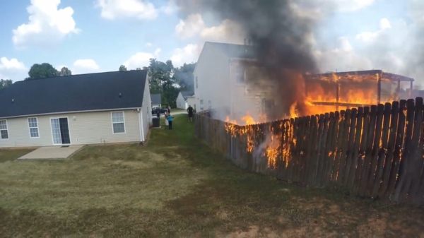 Motorrijder verandert in een brandweerman als hij een achtertuin in de hens ziet staan