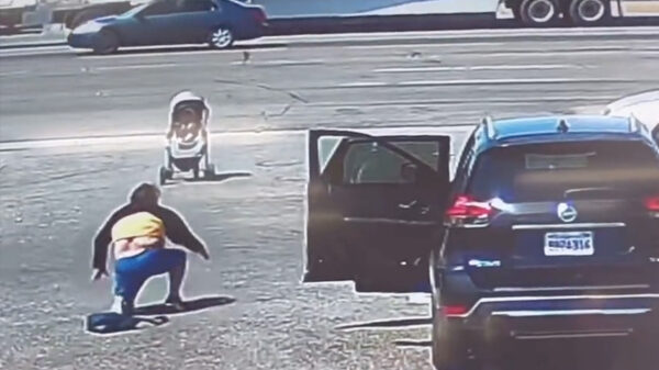 Held van de dag voorkomt dat kinderwagen een drukke straat op rolt in Californië