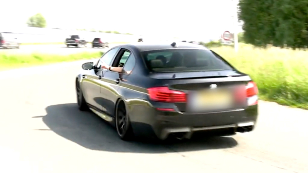 Iets te enthousiaste automobilist drift zijn dikke BMW M5 bijna de berm in