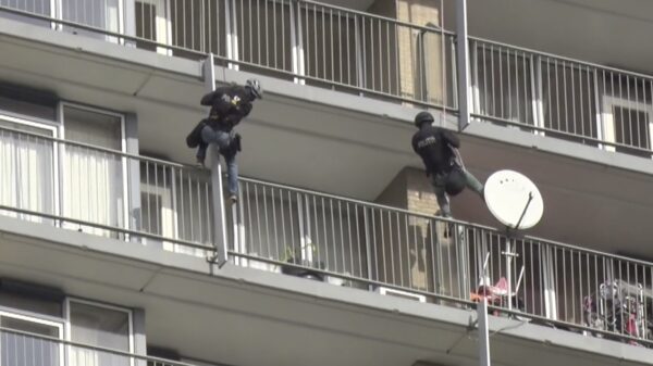 Verwarde man klimt als Spider-Man langs balkons tijdens inval van een arrestatieteam