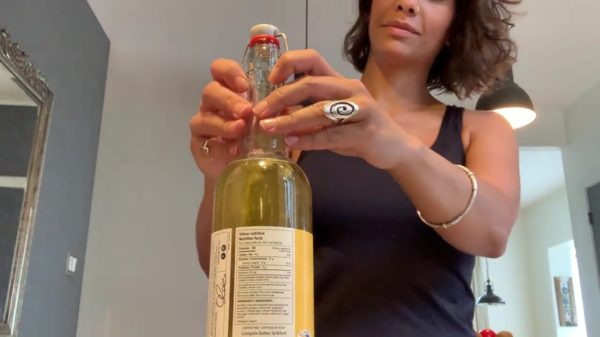 Leuke dame doet een poging tot het openmaken van een beugelfles