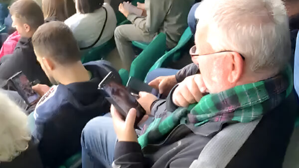 Verveelde Schotse voetbalsupporter betrapt terwijl hij sneaky filmpjes kijkt
