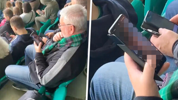 Verveelde Schotse voetbalsupporter betrapt terwijl hij sneaky filmpjes kijkt