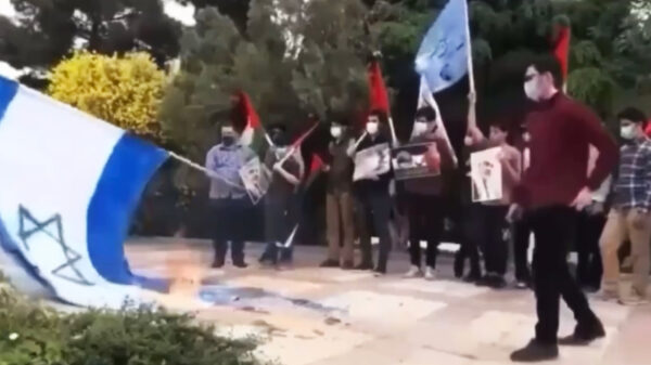 Vuur slaat over op demonstrerende Palestijnen die Israëlische vlag in brand zetten