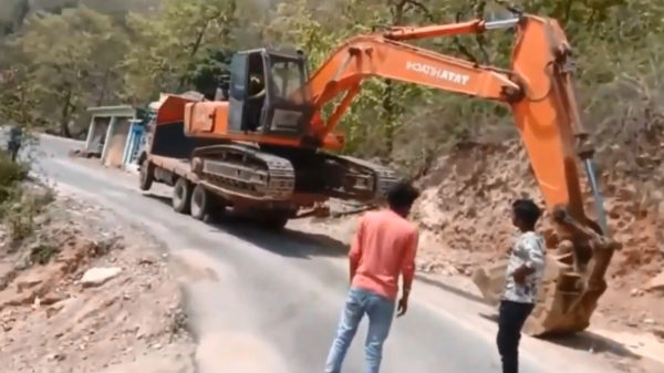 Graafmachine wordt op een spectaculaire manier van aanhanger gelost