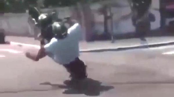 Corpulente scooterrijder doet een dappere poging tot een wheelie