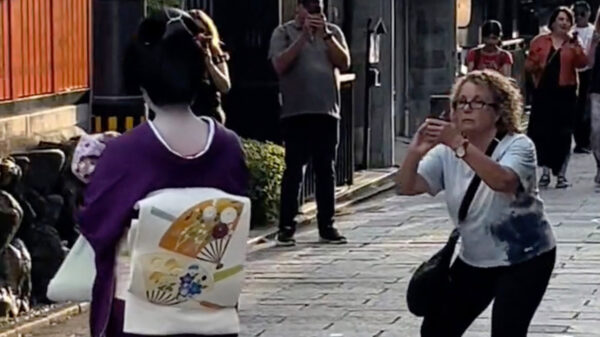 Opdringerige toerist wil in Tokyo per se een foto maken van een vrouw in klederdracht