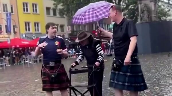 Schotse voetbalsupporters houden bejaarde man droog in Keulen