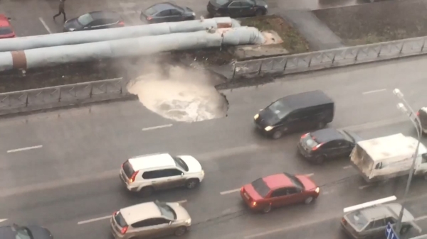 Russische automobilisten rijden rakelings langs sinkhole met kokend heet water