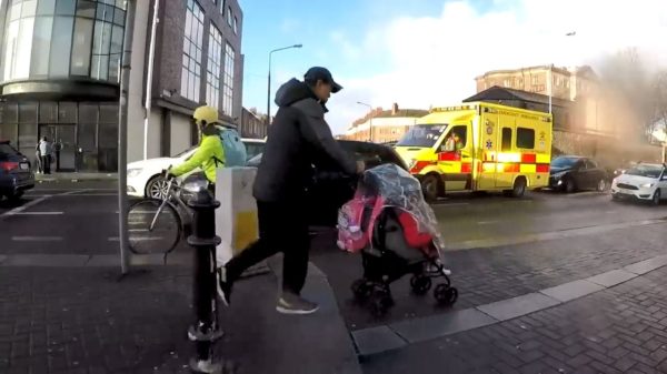 Vader met kind in buggy komt erachter dat het verdomd hard waait