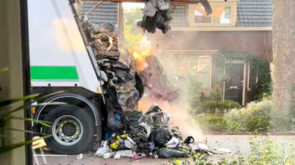 Vuilniswagen dumpt gigantische berg brandend afval op straat