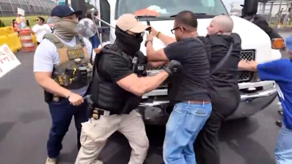 Totaal geflipte anti-ICE activist probeert bus met gedetineerden tegen te houden