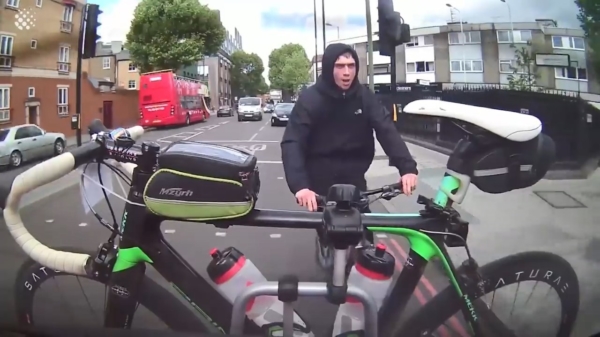 Straatschoffie probeert bij een rood stoplicht een racefiets van een auto te jatten