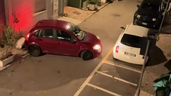 Vrouw stuntelt eindeloos met klein koekblik in smalle Italiaanse straat