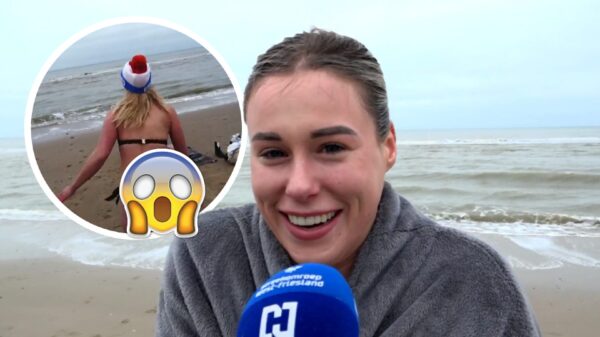 Verslaggeefster test de temperatuur van zeewater voor nieuwjaarsduik