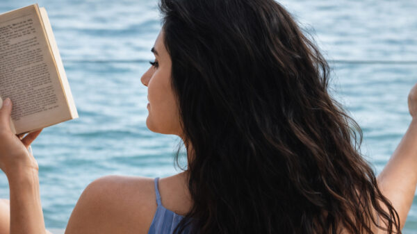 Vrouw geniet op het strand van de zon, de zee en een lekker fris windje