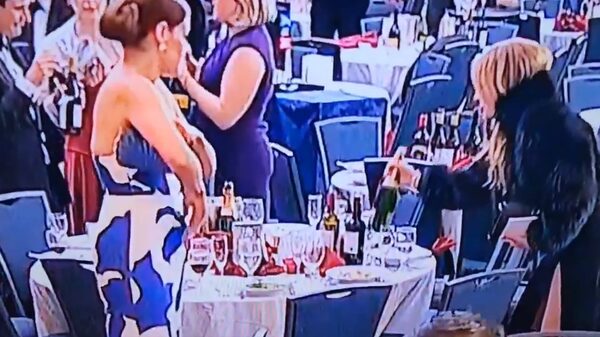 Vrouw in bontjas steelt wijn terwijl de kogels Trump om de oren vlogen