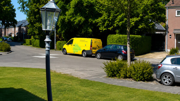 Blinde DHL-bezorger ramt geparkeerde auto bij het achteruitrijden