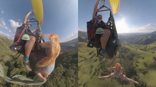 Luchtacrobaat voert krankzinnige stunt uit terwijl ze onder een paraglider bungelt