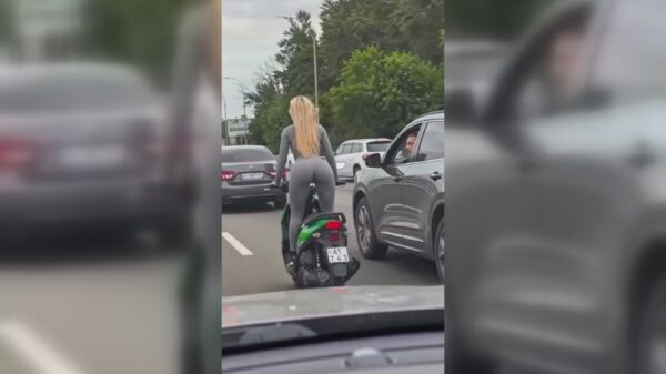 Afgeleid door een blondje op een scooter