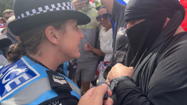 Gezichtsbedekking verboden door politie; man komt in boerka naar protest