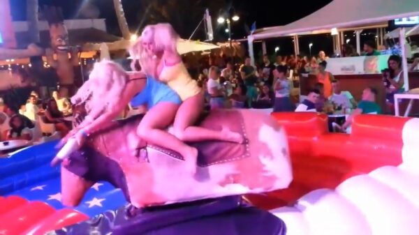 Ritje op een mechanische stier trekt veel bekijks dankzij 2 blondines met een (te) kort rokje