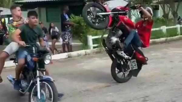 Brokkenpiloot wheeliet zo tegen een paar andere motorrijders aan