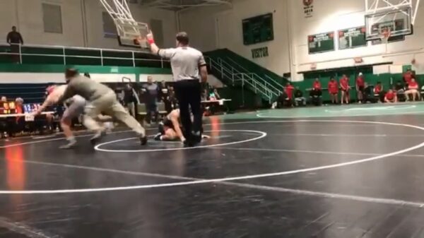 Papa grijpt in en beukt de tegenstander van zijn zoon tegen de grond tijdens worstelwedstrijd