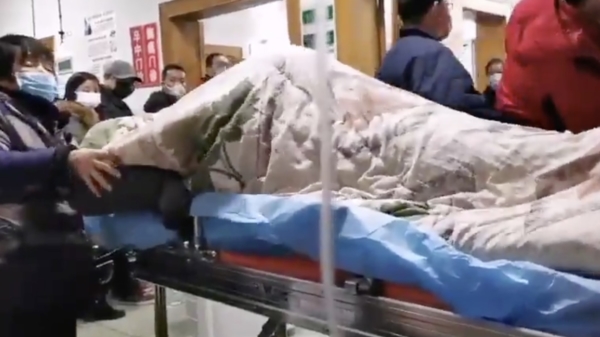 Patiënt die het coronavirus zou hebben ligt schuddend op een ziekenhuisbrancard in Wuhan