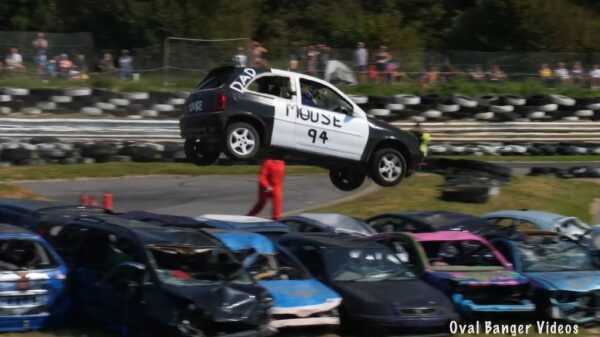 Stuntpiloten jumpen met hun gare rammelkast over auto's bij de Angmering Raceway