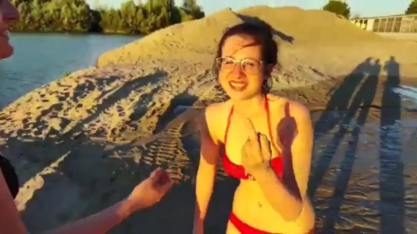 Lieftallig brillenmeisje in bikini maakt heerlijke faceplant op het strand