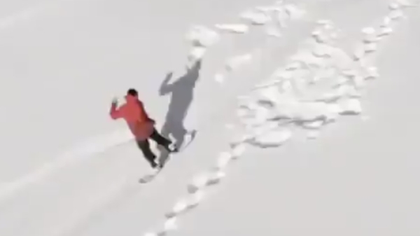 Snowboarder ziet een klein besneeuwd heuveltje over het hoofd