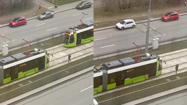 Russische dame met oordoppen in wandelt doodleuk voor aankomende tram uit