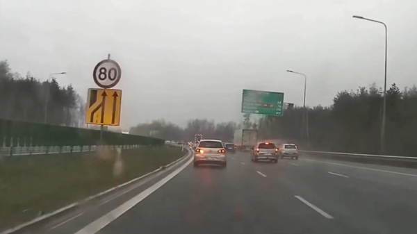 Poolse automobilist is op de snelweg duidelijk met iets anders bezig dan autorijden