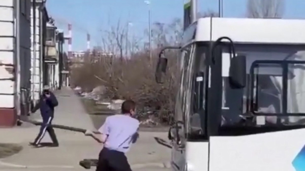 Bezopen Rus met behoorlijk ochtendhumeur slaat busramen in met een schep