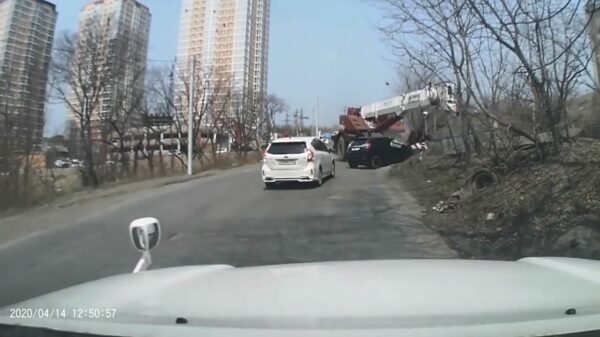 Kraanwagen met defecte remmen knalt bergafwaarts tegen auto en sleurt hem mee