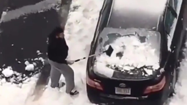 Idioot sloopt autoruit tijdens het weghakken van de sneeuw