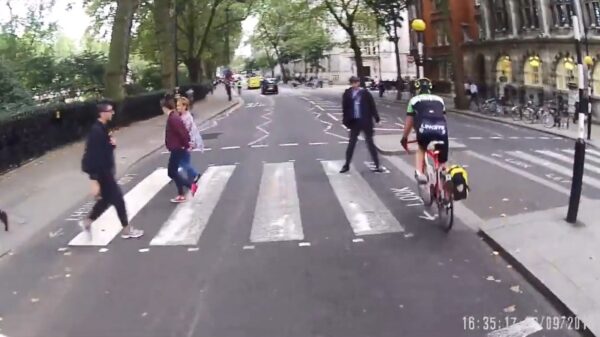 Voetganger zorgt ervoor dat deze wielrenner gewoon moet stoppen voor het zebrapad